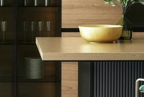 Moderne keuken met houten tafel, gouden kom, glazen kast en houten wandpanelen met planten