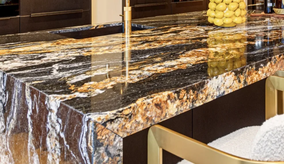 Moderne keuken met zwart-goud gemarmerd granieten aanrecht en glazen vaas met gele citroenen