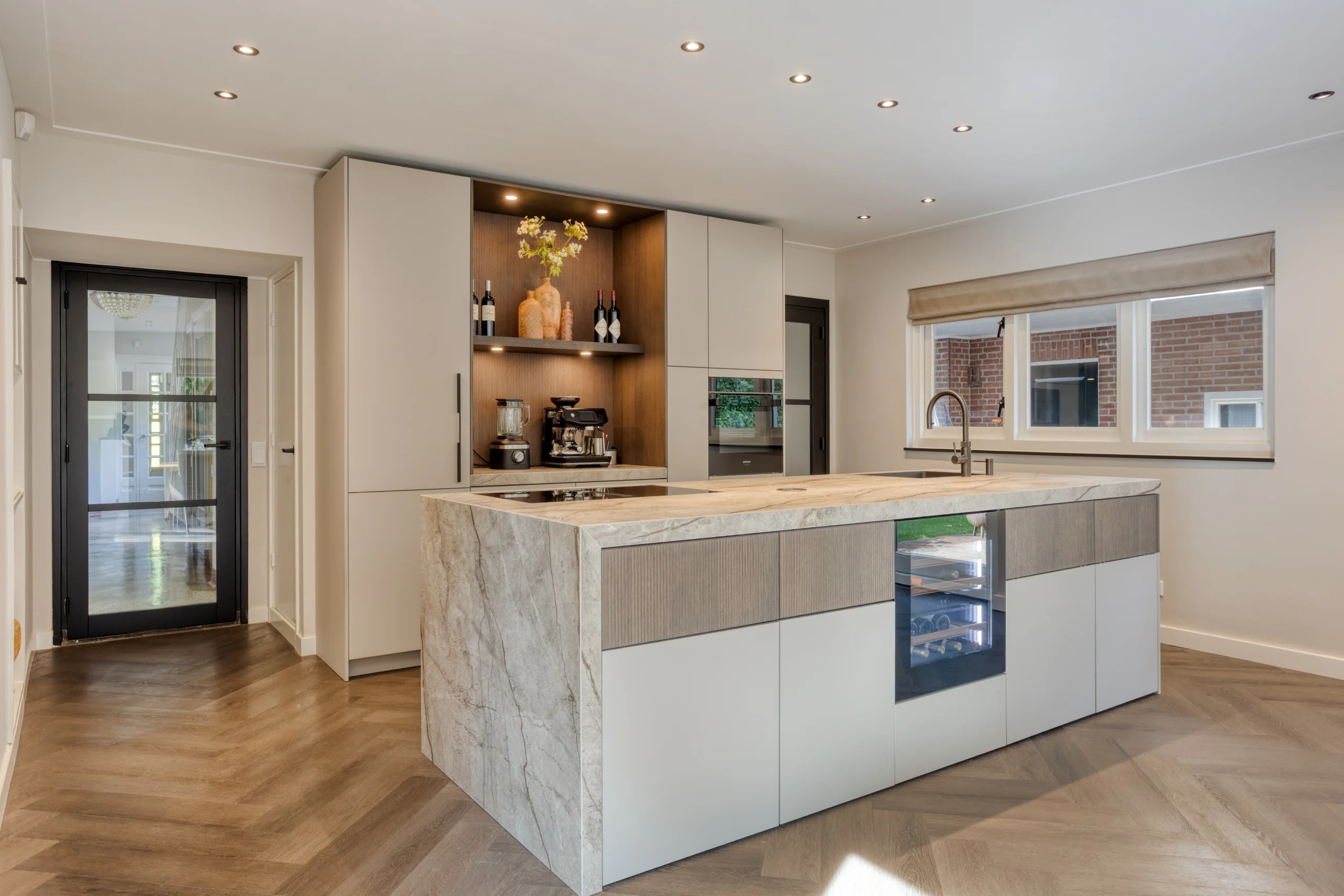 Moderne japandi keuken met marmeren kookeiland, houten accenten en hoge kasten bij groot raam